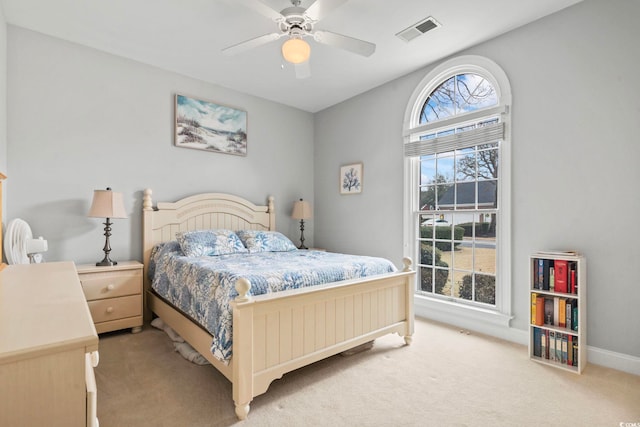 bedroom with light colored carpet, visible vents, ceiling fan, and baseboards