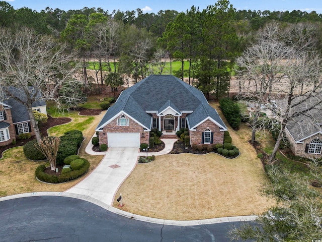 exterior space featuring a garage, driveway, brick siding, and a front lawn