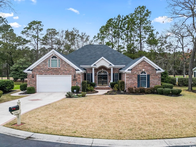 view of front of property featuring a front yard, french doors, concrete driveway, and brick siding