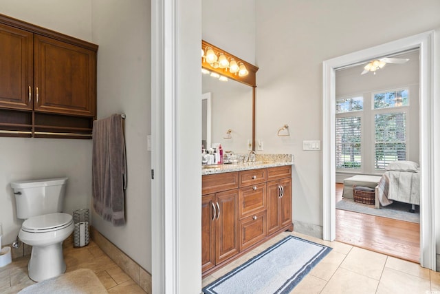 ensuite bathroom featuring ensuite bathroom, toilet, vanity, baseboards, and tile patterned floors