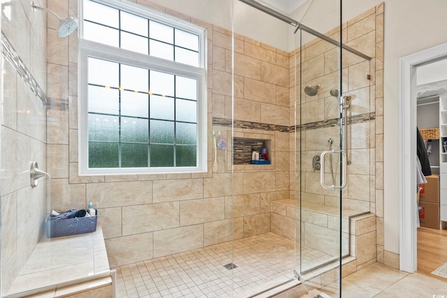 bathroom featuring plenty of natural light, a shower stall, and tile patterned floors