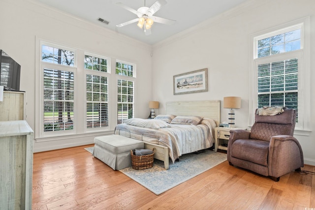 bedroom featuring ornamental molding, visible vents, and light wood-style floors