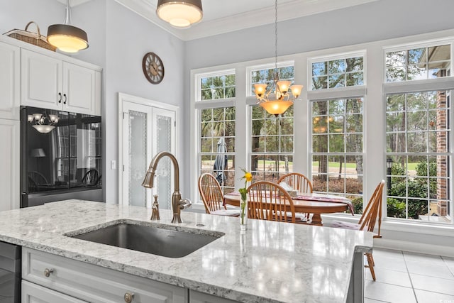 kitchen featuring decorative light fixtures, a notable chandelier, ornamental molding, white cabinetry, and a sink