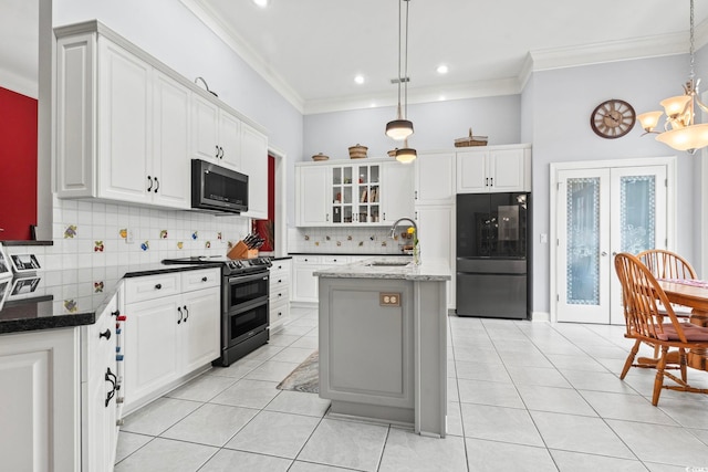 kitchen with light tile patterned floors, appliances with stainless steel finishes, a sink, and french doors