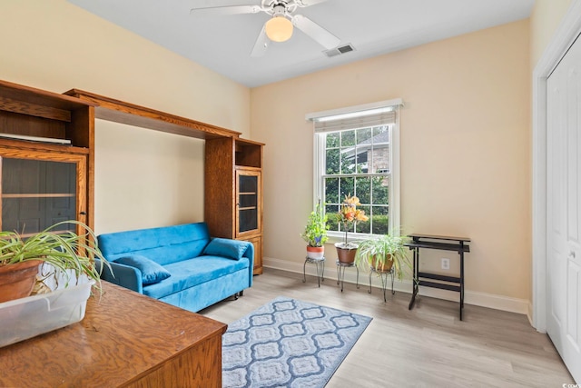 sitting room featuring baseboards, visible vents, ceiling fan, and wood finished floors