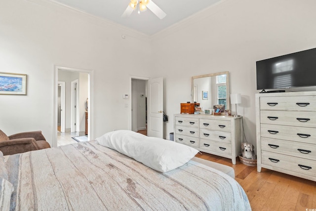 bedroom with ceiling fan, ornamental molding, a towering ceiling, and light wood-style floors