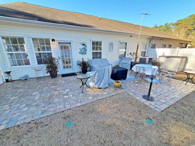 back of house featuring a shingled roof, a patio, and fence