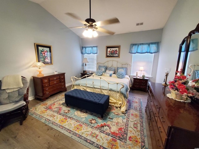 bedroom with lofted ceiling, visible vents, ceiling fan, wood finished floors, and baseboards