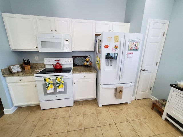 kitchen with white appliances, dark countertops, and white cabinets