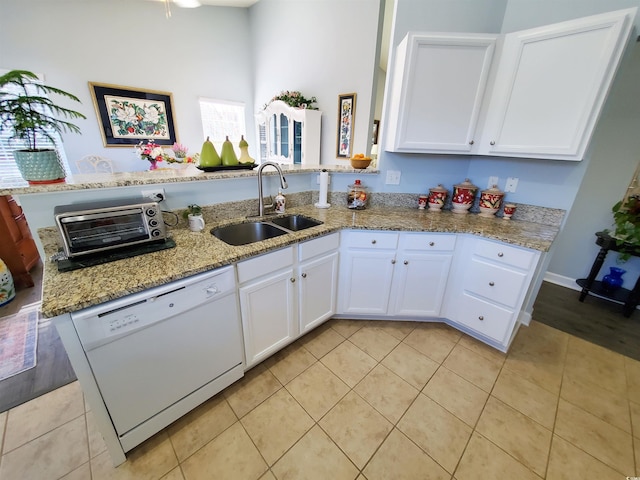 kitchen featuring white cabinetry, dishwasher, a sink, and light stone countertops