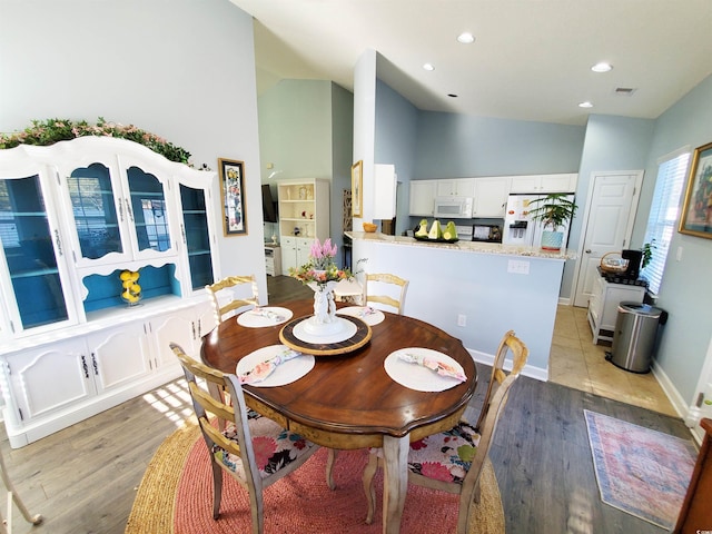 dining area featuring recessed lighting, visible vents, vaulted ceiling, and light wood finished floors