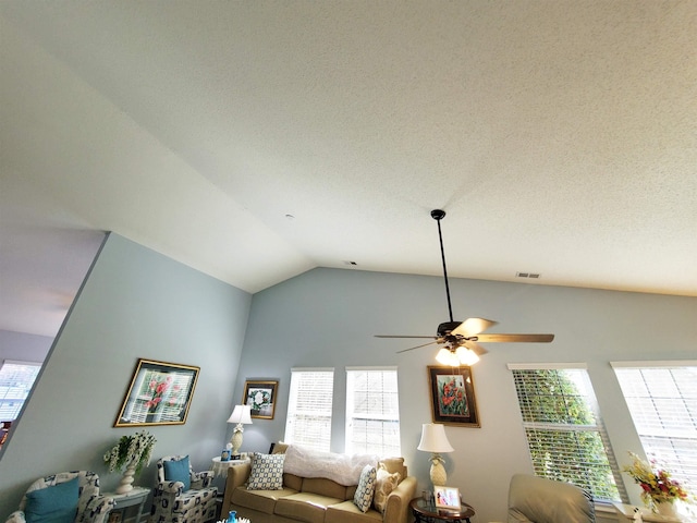 living area featuring vaulted ceiling, visible vents, a wealth of natural light, and a ceiling fan