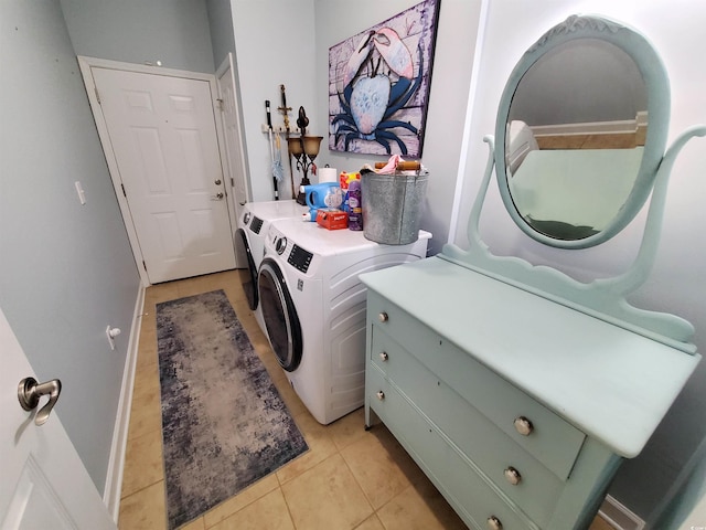 laundry room with light tile patterned floors, baseboards, laundry area, and washing machine and clothes dryer