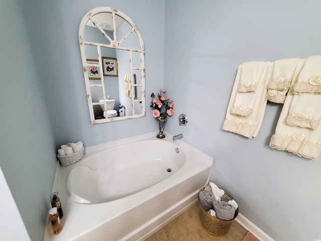 full bath featuring a garden tub, baseboards, and tile patterned floors