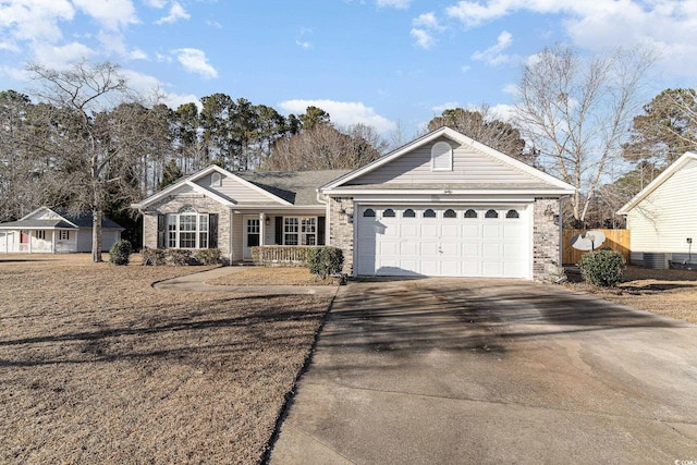 single story home with covered porch, brick siding, driveway, and an attached garage