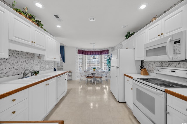 kitchen featuring white appliances, a sink, visible vents, and white cabinetry