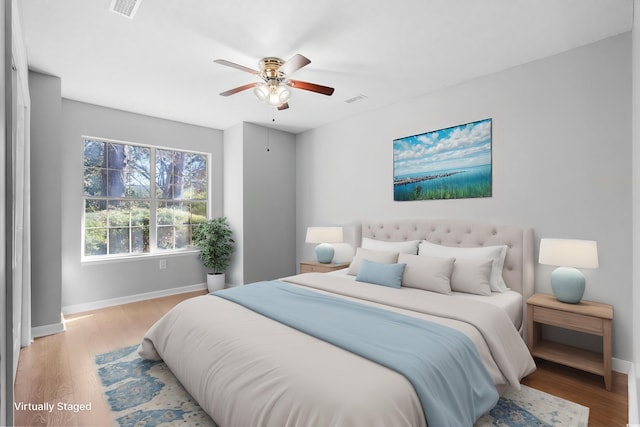 bedroom featuring light wood-style floors, visible vents, ceiling fan, and baseboards