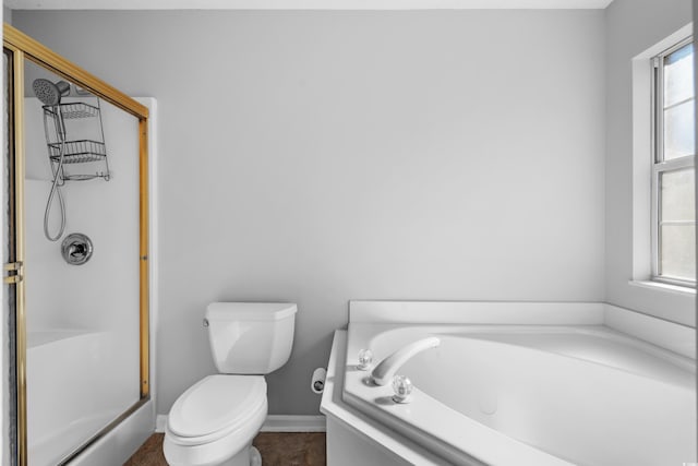 bathroom featuring baseboards, a garden tub, toilet, and a shower with door