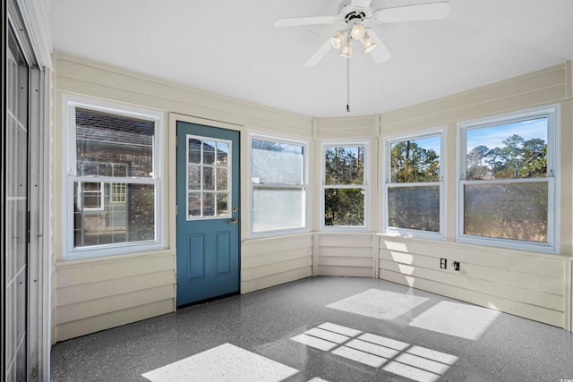 unfurnished sunroom featuring ceiling fan