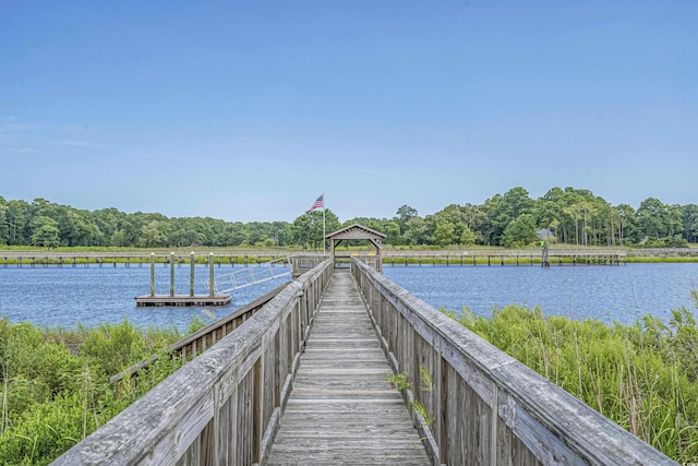 dock area featuring a water view, a view of trees, and a gazebo