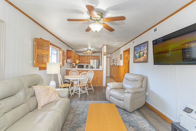 living room featuring ceiling fan, dark wood-style flooring, visible vents, and crown molding