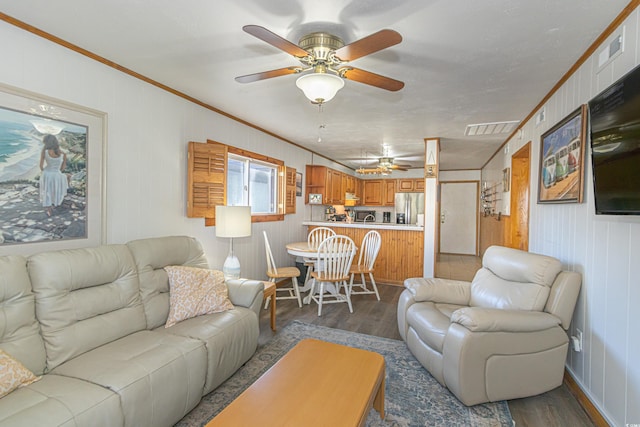 living area with ceiling fan, dark wood-type flooring, visible vents, and crown molding