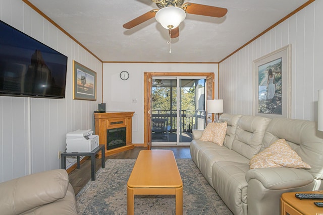 living room with dark wood-style flooring, a fireplace, crown molding, and ceiling fan