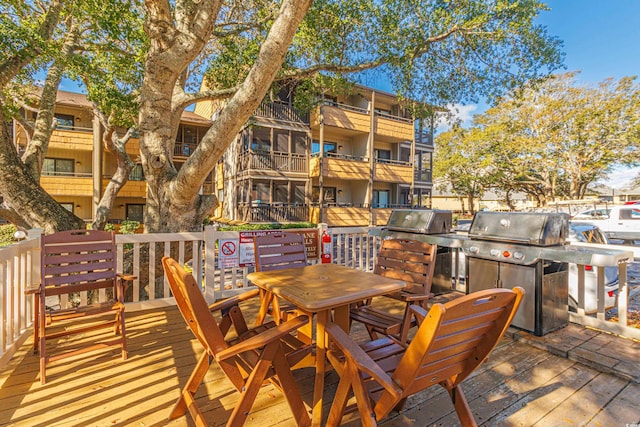 wooden terrace featuring area for grilling and a grill