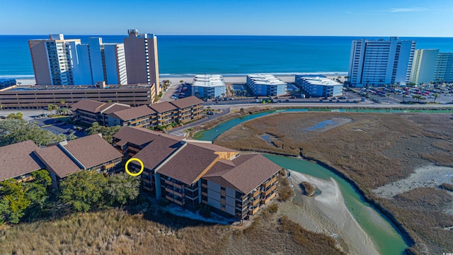 birds eye view of property featuring a beach view and a water view