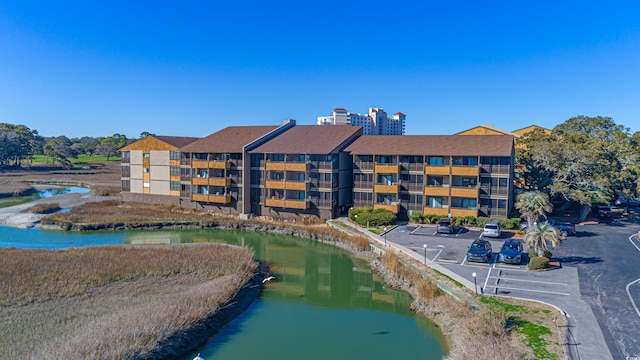 view of property featuring a water view and uncovered parking