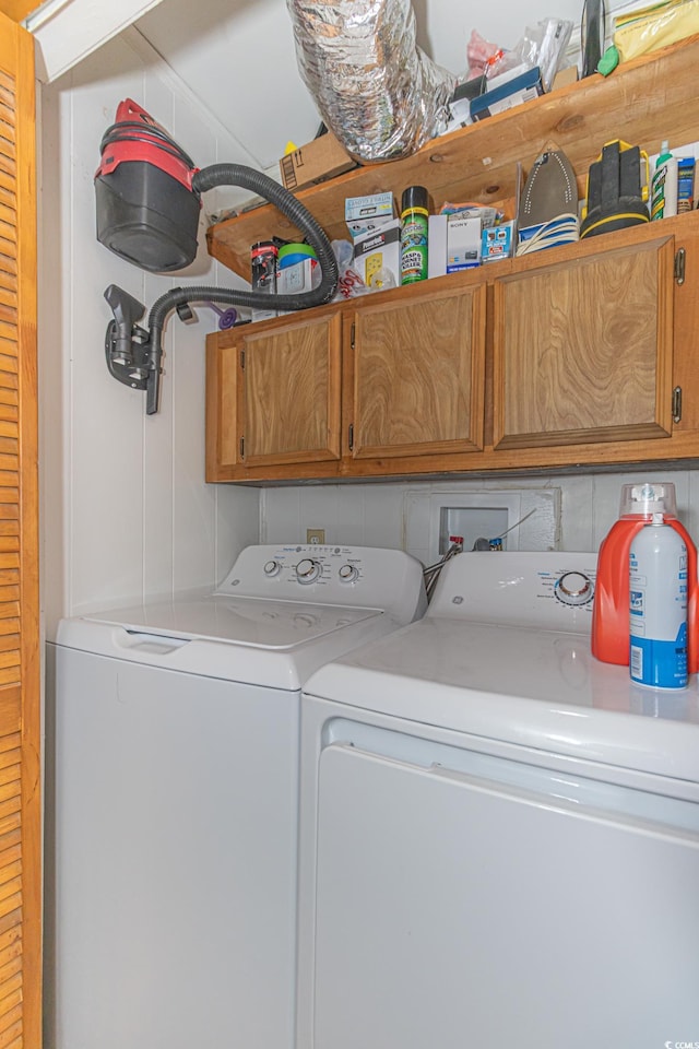 clothes washing area with cabinet space and separate washer and dryer