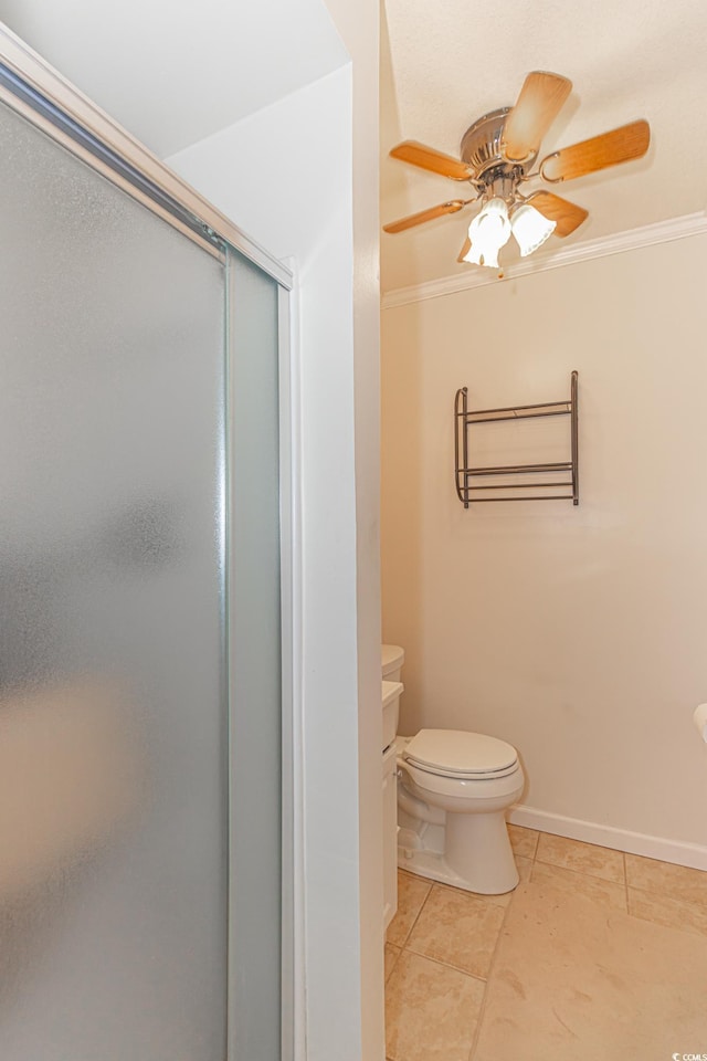 full bathroom featuring a stall shower, baseboards, ceiling fan, ornamental molding, and tile patterned floors