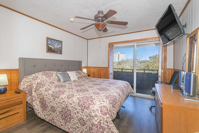 bedroom featuring dark wood-style floors, access to outside, wainscoting, and crown molding