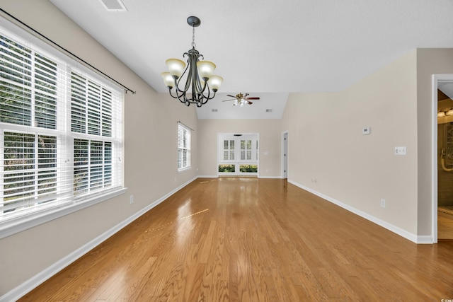 interior space featuring light wood-type flooring, visible vents, baseboards, and ceiling fan with notable chandelier