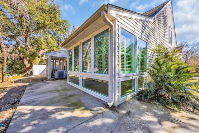 view of side of property with a patio, central AC unit, and a sunroom