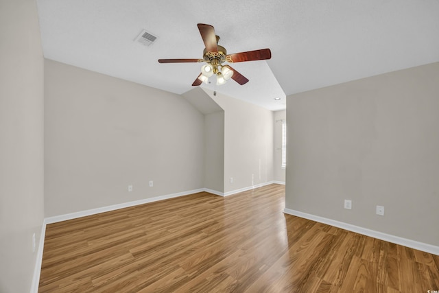 empty room featuring light wood-style floors, visible vents, baseboards, and a ceiling fan