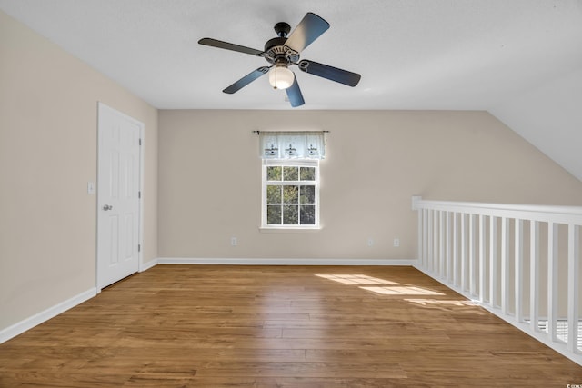 additional living space featuring vaulted ceiling, ceiling fan, wood finished floors, and baseboards