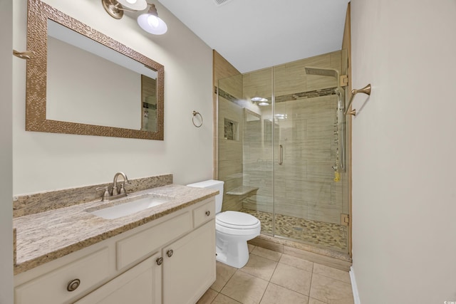 bathroom featuring toilet, a stall shower, tile patterned flooring, and vanity