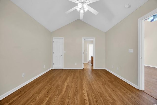 unfurnished bedroom featuring baseboards, ceiling fan, vaulted ceiling, and light wood-style floors