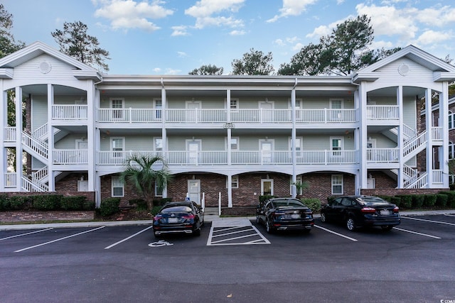 view of property featuring stairs and uncovered parking