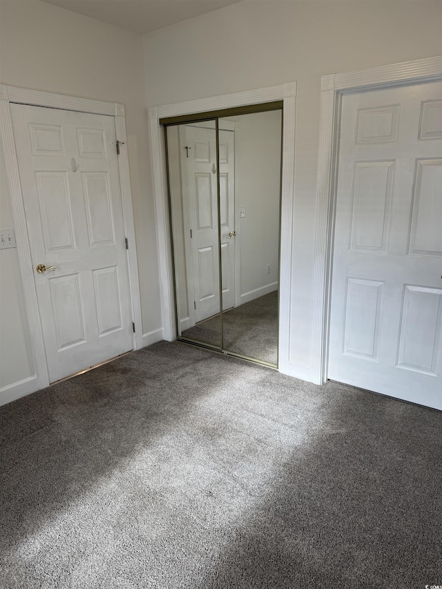 unfurnished bedroom with a closet, carpet, and baseboards