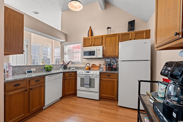 kitchen featuring light wood-type flooring, white appliances, brown cabinets, and light stone countertops