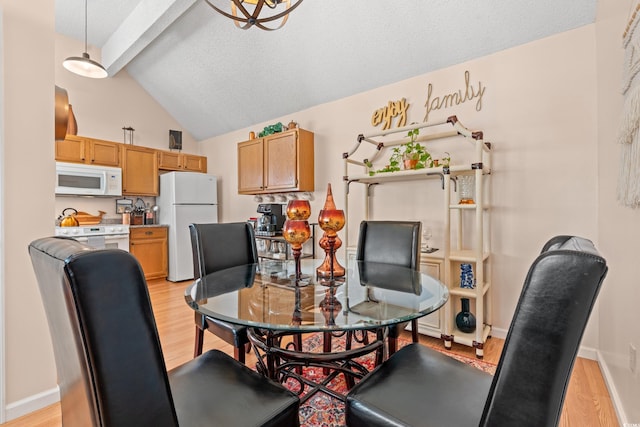 dining space with lofted ceiling with beams, baseboards, and light wood-style floors