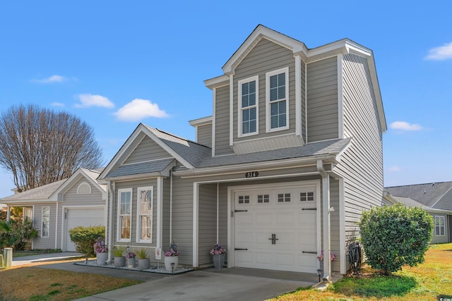 traditional-style home featuring an attached garage, a shingled roof, and concrete driveway