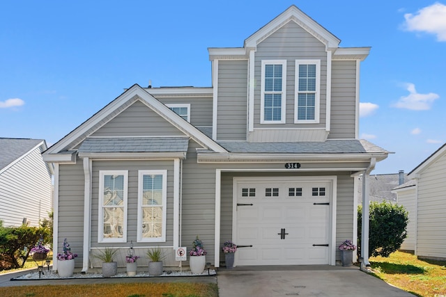 view of front of home featuring concrete driveway, roof with shingles, and an attached garage