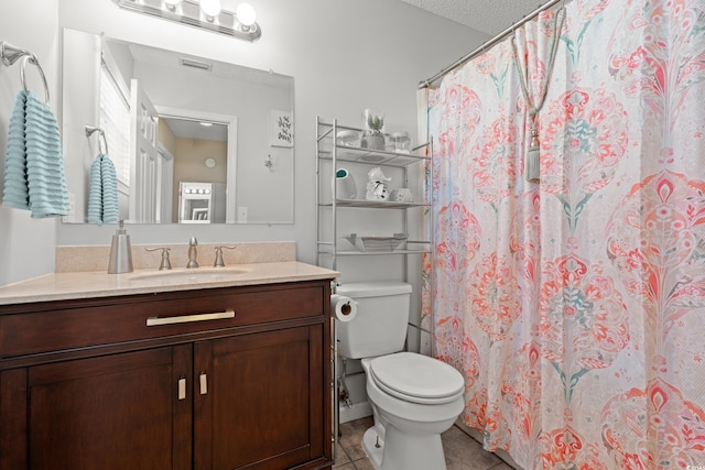 bathroom featuring curtained shower, vanity, toilet, and tile patterned floors