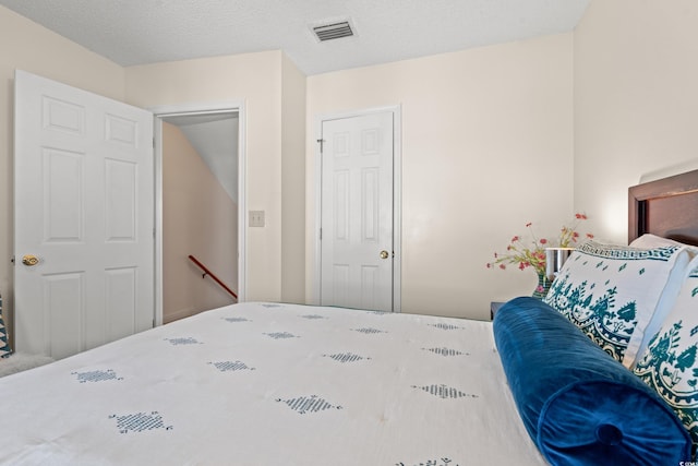 bedroom featuring a textured ceiling and visible vents