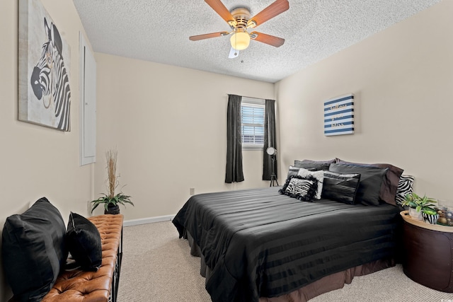 bedroom featuring a textured ceiling, baseboards, a ceiling fan, and light colored carpet