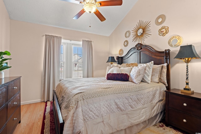 bedroom with lofted ceiling, light wood-style flooring, baseboards, and a ceiling fan