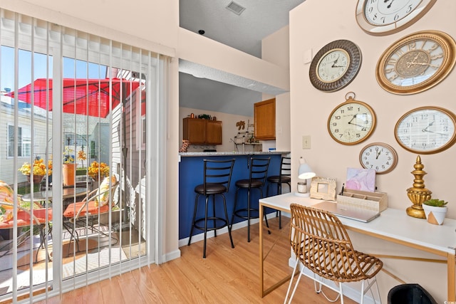 interior space featuring light wood-style floors, visible vents, and a textured ceiling